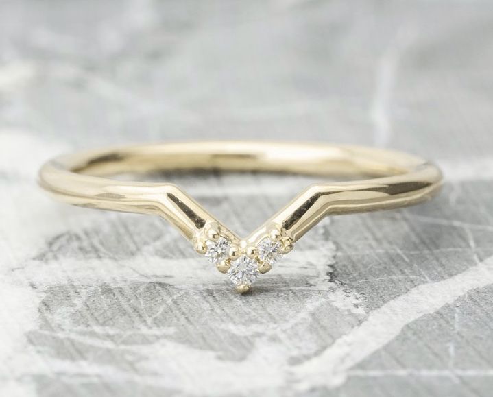 a yellow gold ring with two diamonds on it