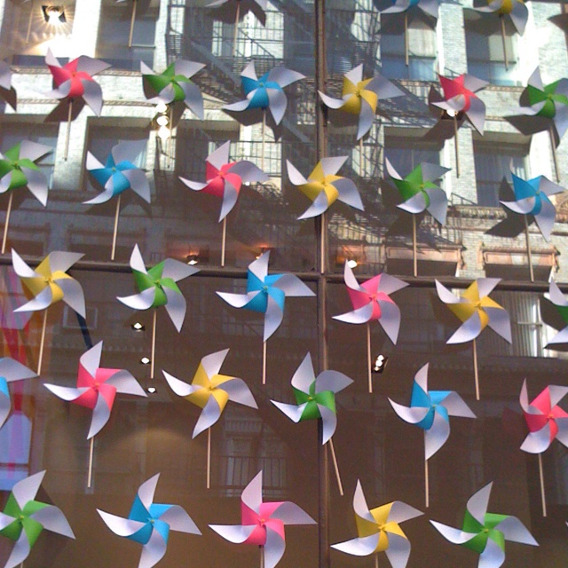 several colorful pinwheels are hanging in front of a window