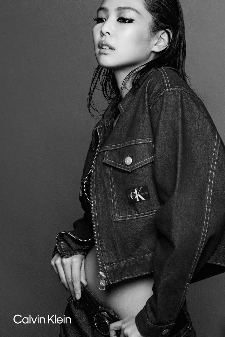 black and white photograph of a woman in jean jacket posing for the camera with her hands on her hips