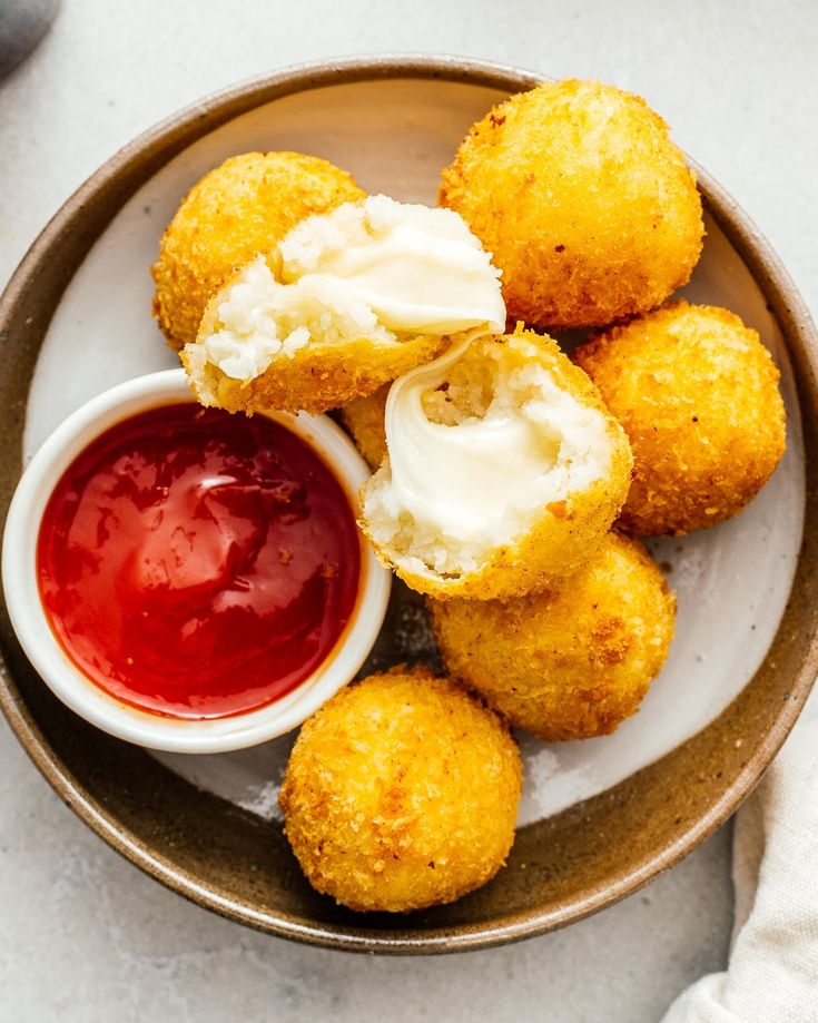 fried food on a plate with ketchup and mayonnaise in the middle