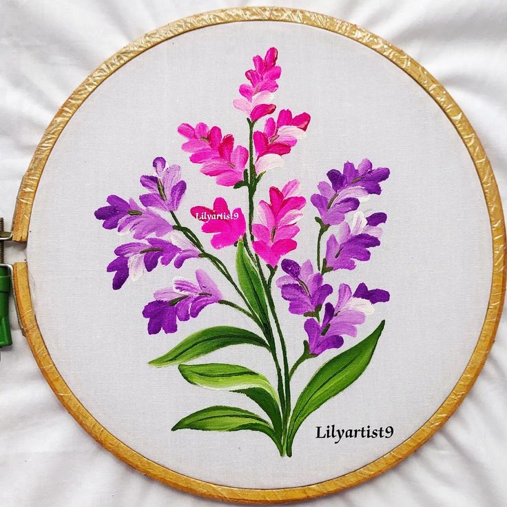 a cross stitch pattern with purple flowers in the center and green leaves on the bottom