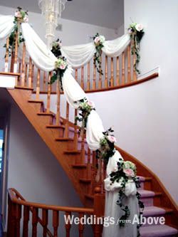 a staircase decorated with white flowers and greenery