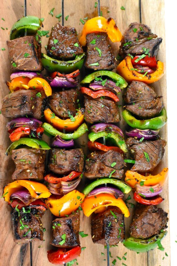 steak and peppers on skewers are ready to be grilled in the oven