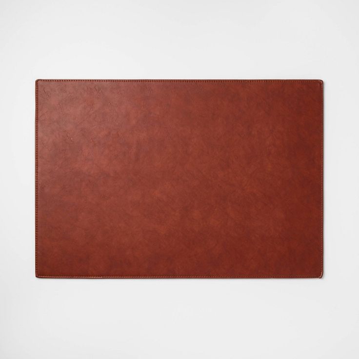 a brown leather place mat on a white background