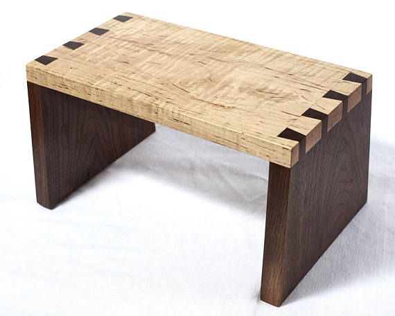 a wooden bench made out of pieces of wood with holes in the top and bottom