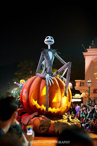 a skeleton sitting on top of a pumpkin