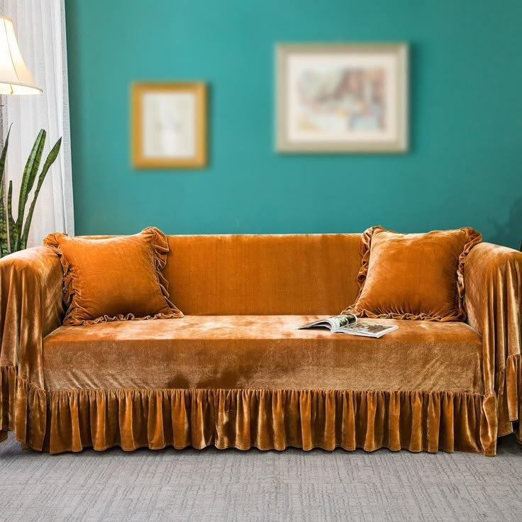 a living room with a couch, lamp and pictures hanging on the wall behind it