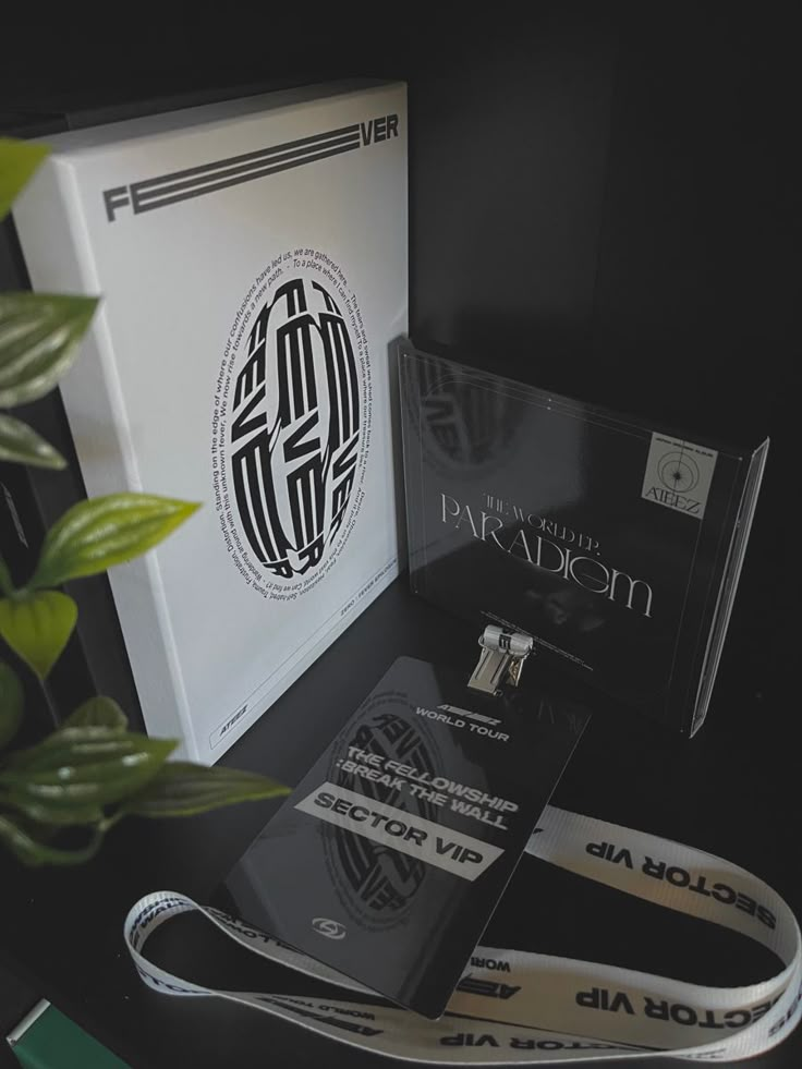 an assortment of lanyards are displayed on a black table with a plant in the corner