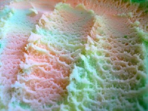 a close up view of a crocheted dishcloth with green and pink colors