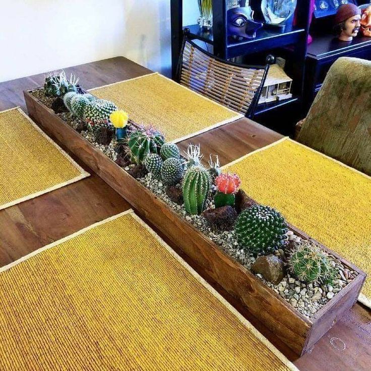 a wooden planter filled with lots of succulents on top of a table