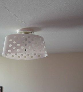 a white lamp hanging from the ceiling in a bedroom