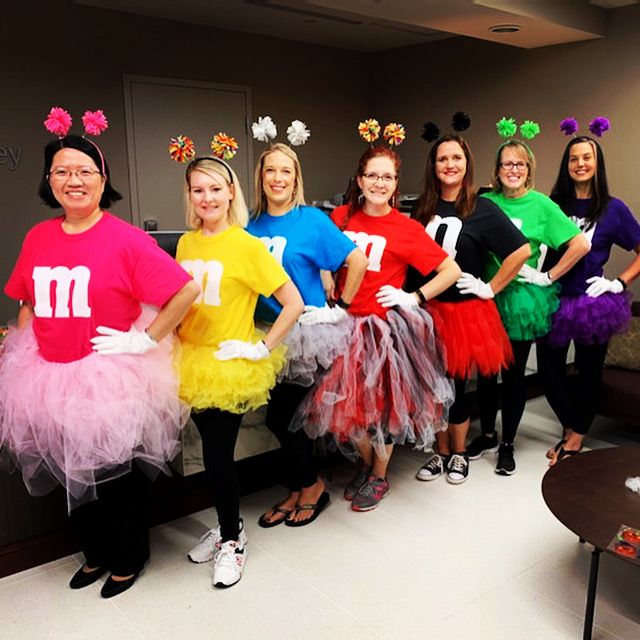 a group of women standing next to each other wearing costumes and posing for the camera