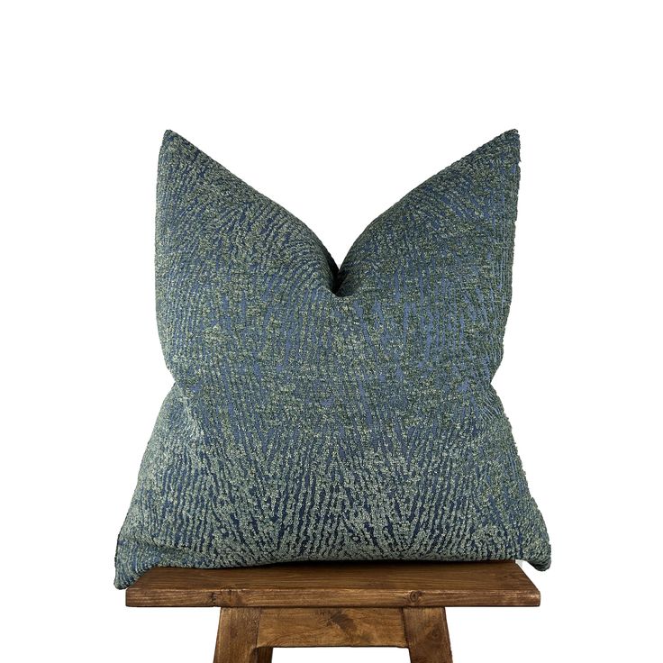 a blue pillow sitting on top of a wooden stool