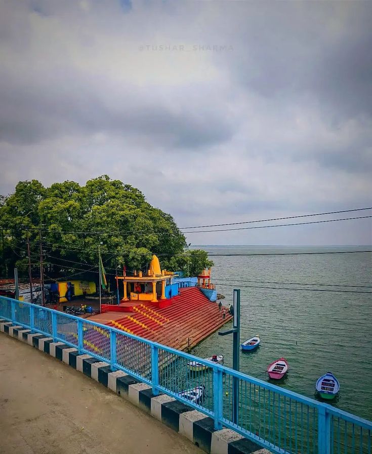 a large boat sitting on top of a body of water next to a blue fence