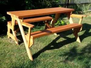 two wooden benches sitting on top of a lush green field