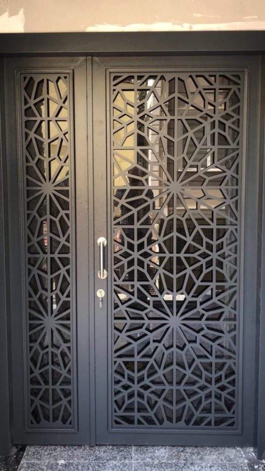 an ornate iron door on the side of a building