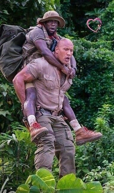 two men in the jungle carrying each other on their back and one man with a backpack