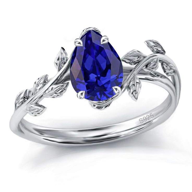 a blue sapphire ring with leaves on the band and an oval cut stone in the center