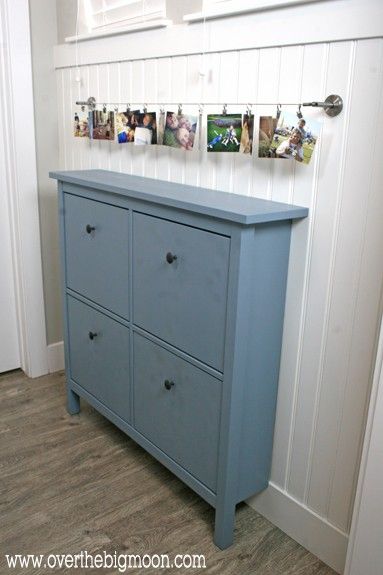 a blue dresser with pictures hanging on the wall