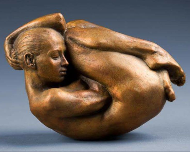 a bronze sculpture of a woman holding a baby in her arms, against a gray background