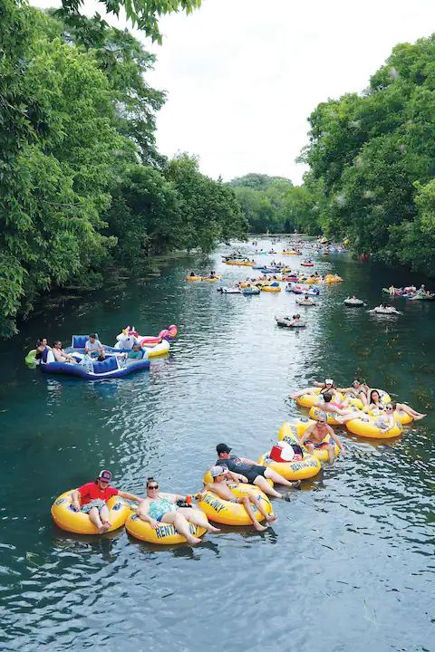 many people are floating down the river on rafts and inflatables,