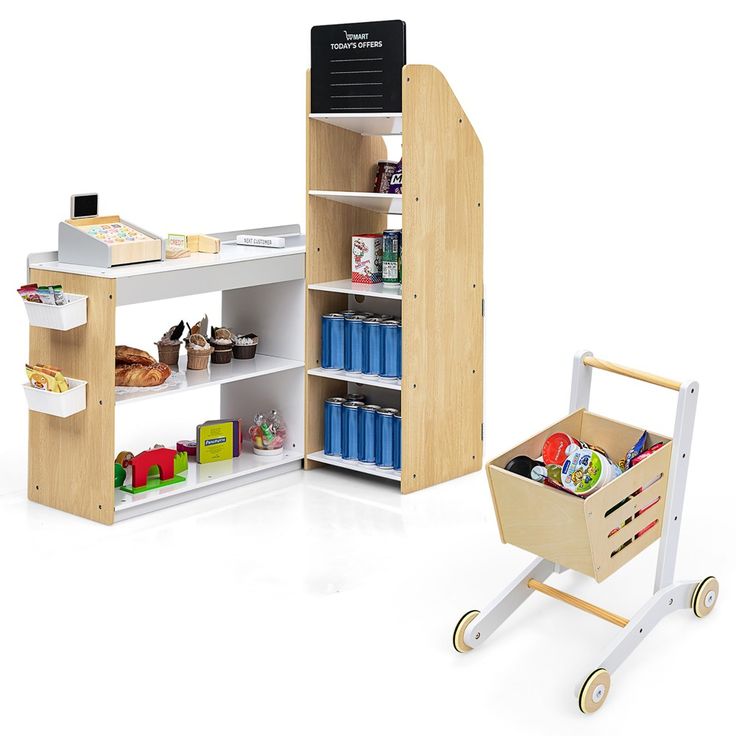 a toy grocery cart next to a wooden shelf with food in it and a cardboard box on wheels