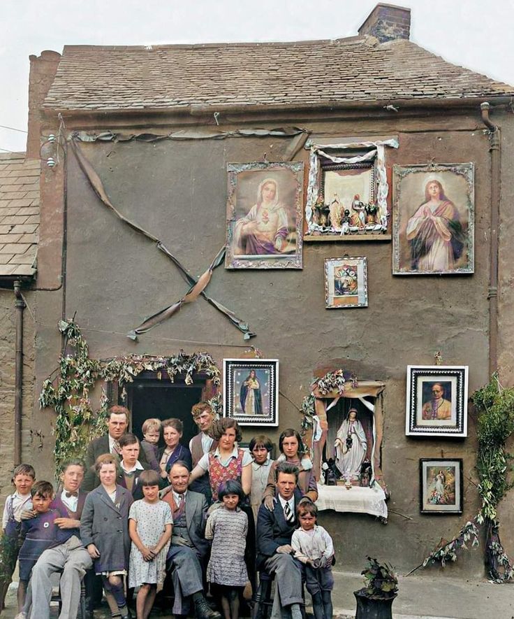 a group of people standing in front of a building with pictures on the side of it