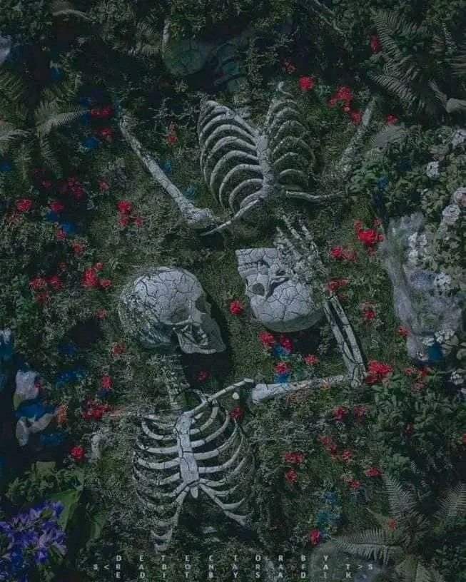 two skeletons sitting in the middle of flowers