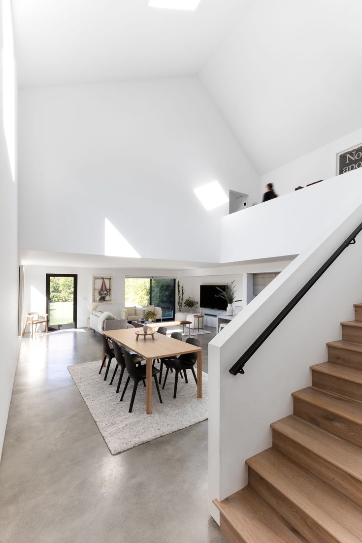 an open floor plan with white walls and wooden stairs