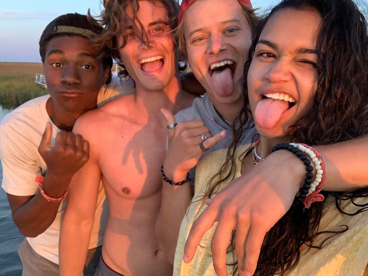 four people are taking a selfie with their tongue out and one person is sticking his tongue out