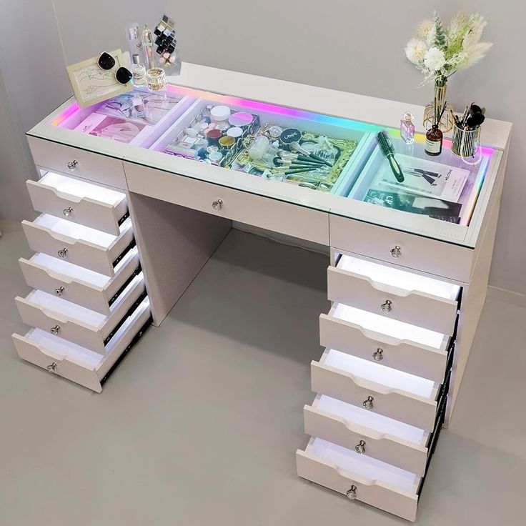 a white desk with drawers and flowers on it