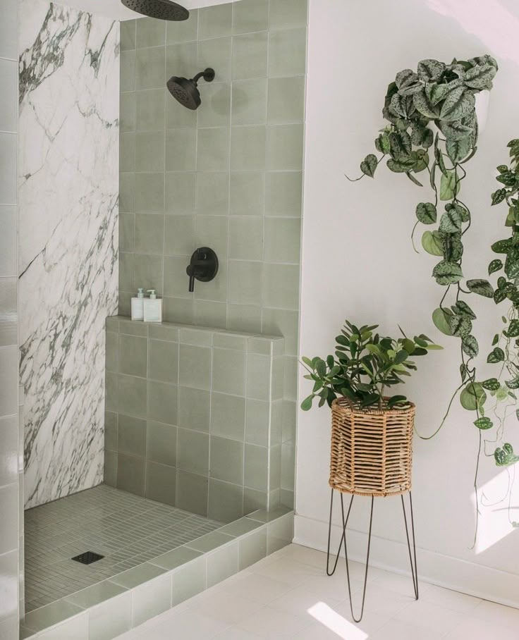 a bathroom with green tile and plants in the shower