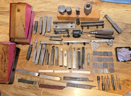 many different tools are laid out on a wooden table with some knives and other items