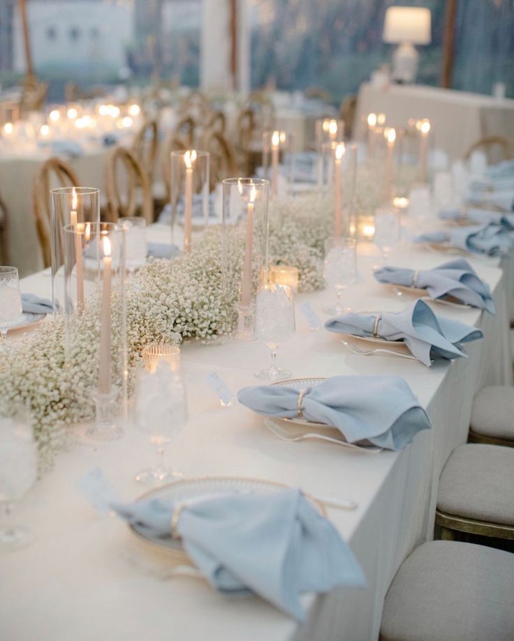 a long table is set with white flowers and candles