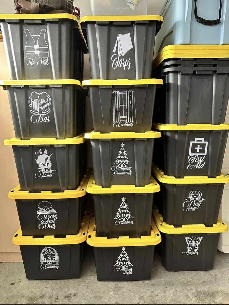 a stack of black and yellow plastic containers with stickers on the lids are stacked next to each other