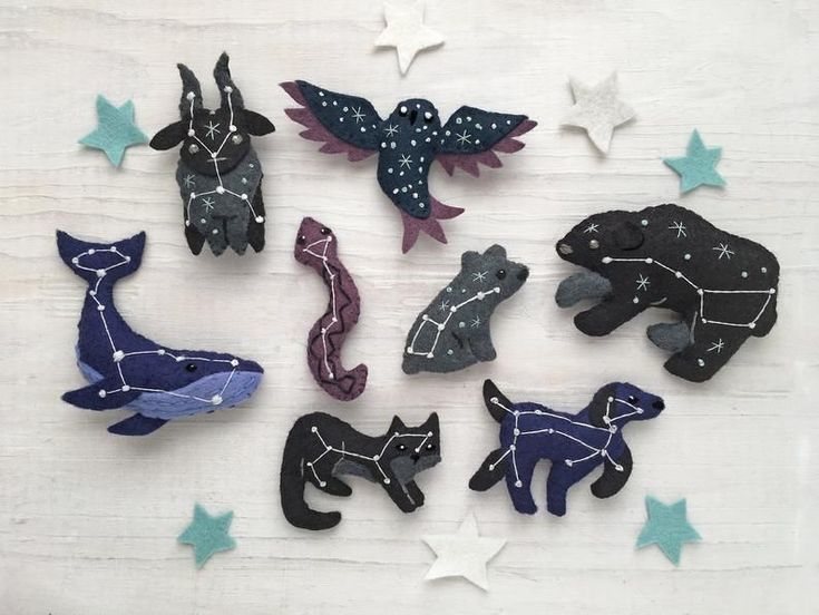 twelve handmade wooden animals with stars in the background on a white wood table top