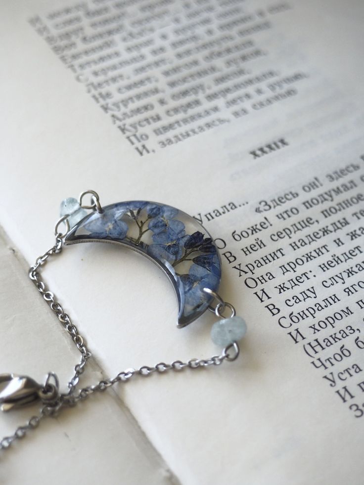 a book with a chain attached to it and a blue moon charm hanging from the front