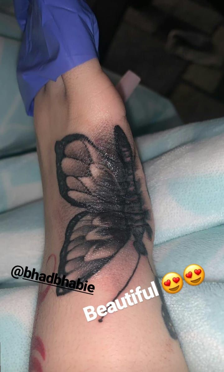 a black and white butterfly tattoo on the leg