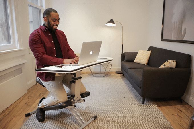 a man sitting at a desk using a laptop computer