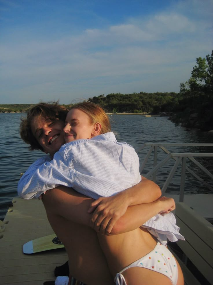 a man holding a woman on the back of a boat