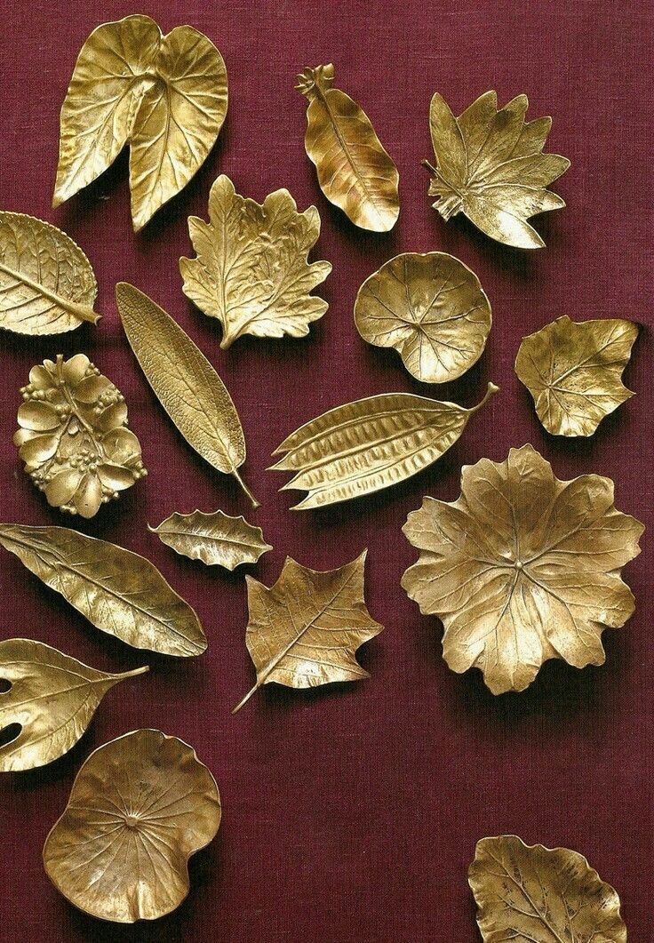 gold leaf shapes are arranged on a red surface