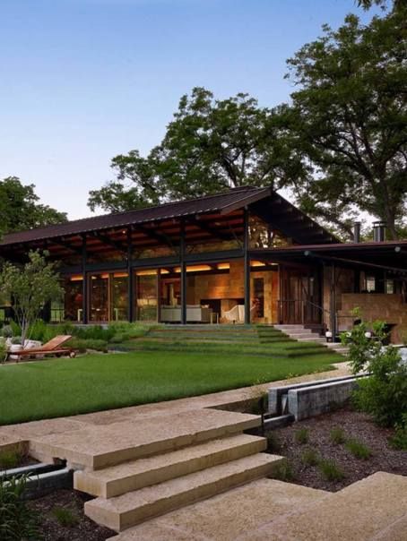 the exterior of a modern house with grass and trees