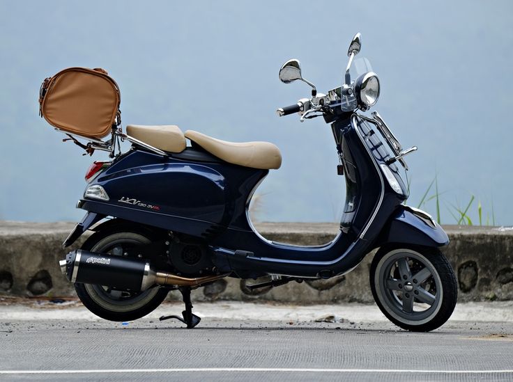 a blue scooter parked on the side of the road