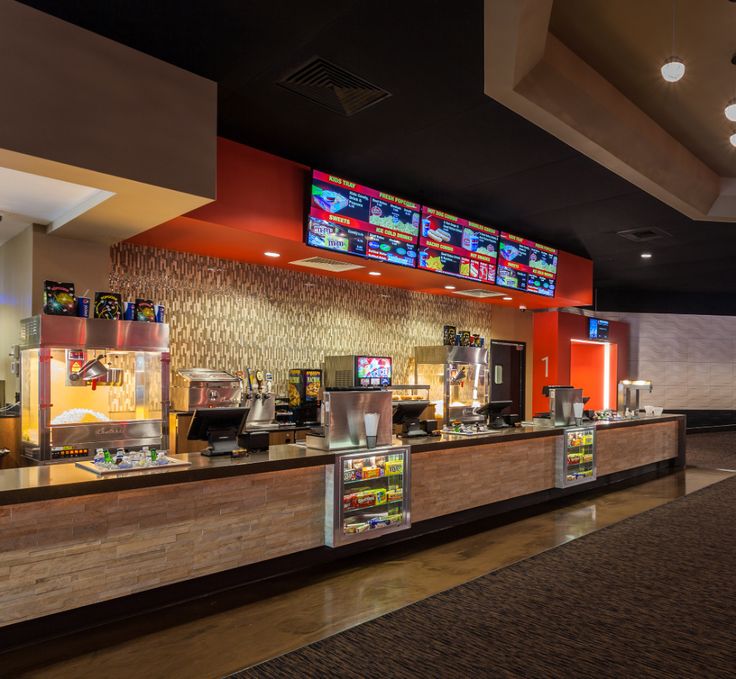 the inside of a fast food restaurant with menus on the counter and television screens above