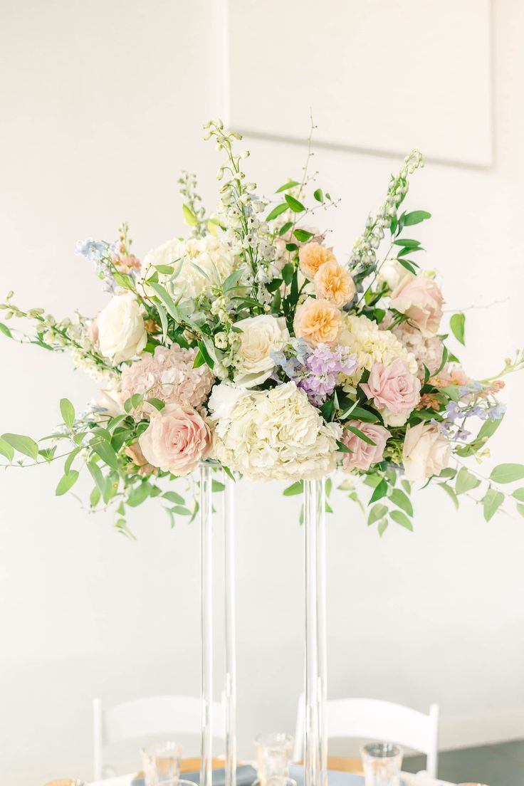 the centerpieces are arranged in tall clear vases with flowers and greenery