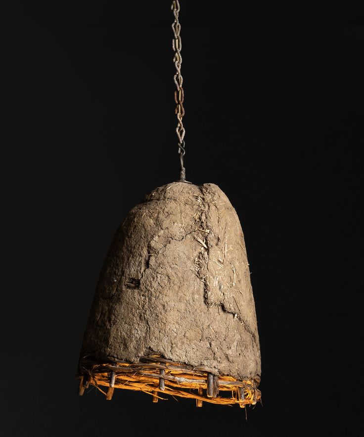 a bird feeder hanging from a chain on a black background in the shape of a rock