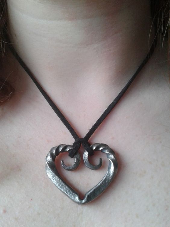 a woman wearing a heart shaped pendant on her neck