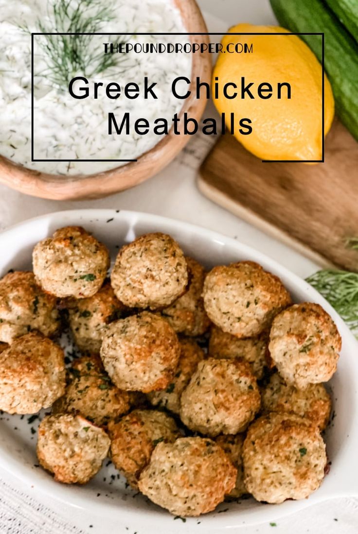 greek chicken meatballs in a white bowl next to cucumbers