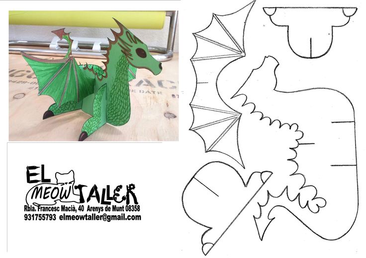 an image of a paper cut out of a green dragon with wings and tail sitting on top of a table