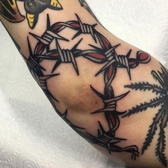 a tattoo with barbed wire on the arm